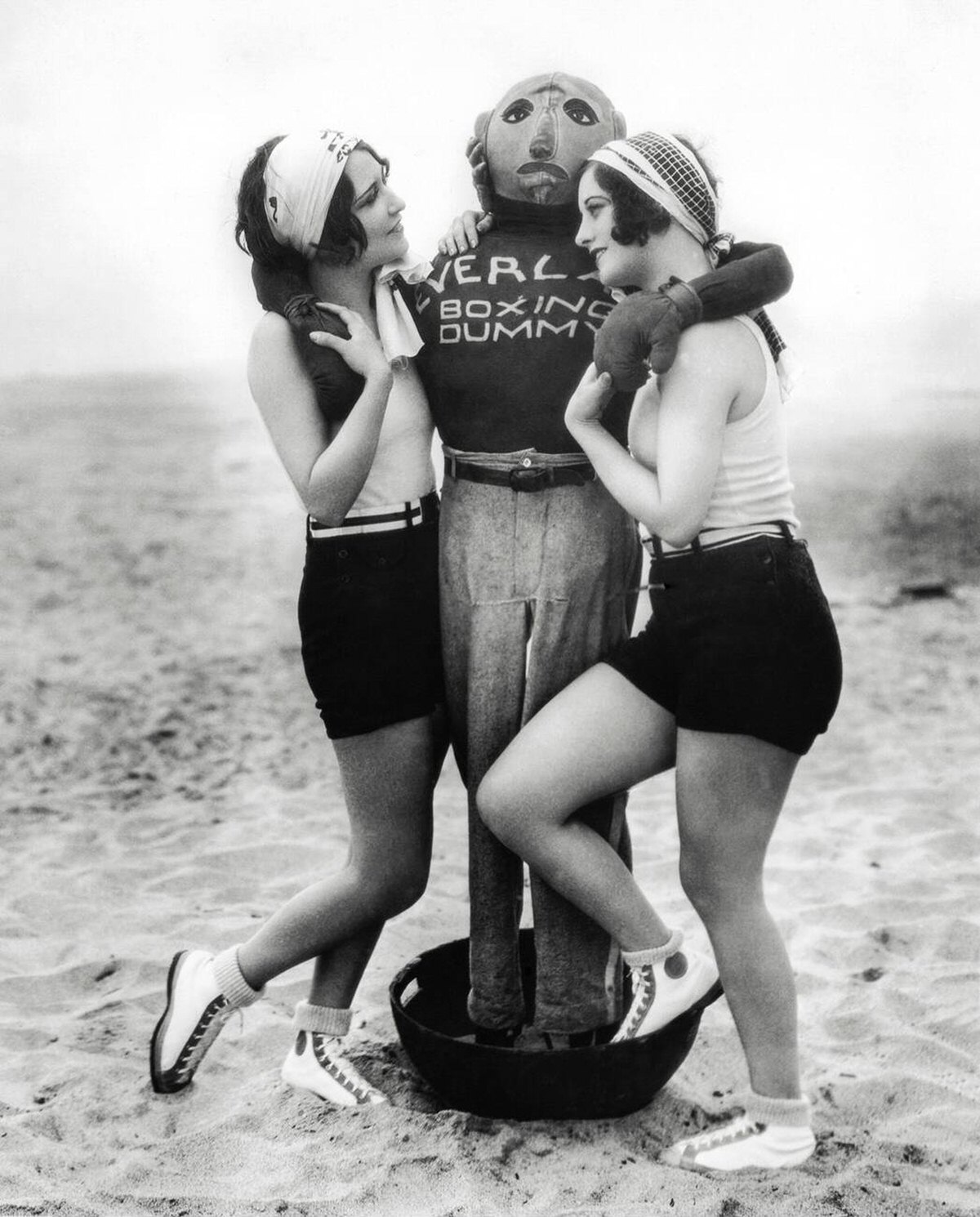 Actresses Dorothy Sebastian and Joan Crawford with a boxing dummy in Hollywood, 1927