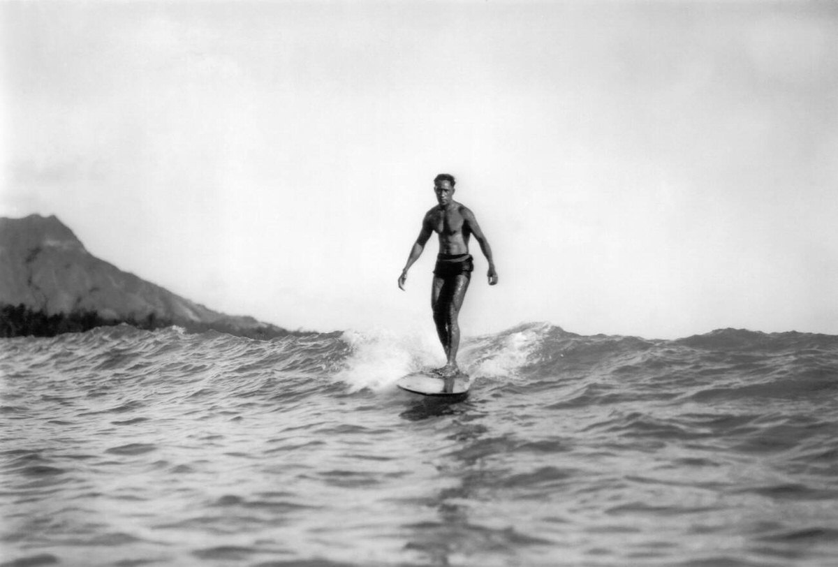 Duke Kahanamoku riding a wave on a wooden surfboard in Waikiki, Hawaii, 1929