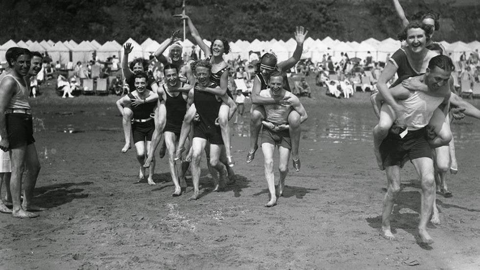 Holiday makers having a piggyback race on the beach at Shanklin on the Isle of Wight, 1928