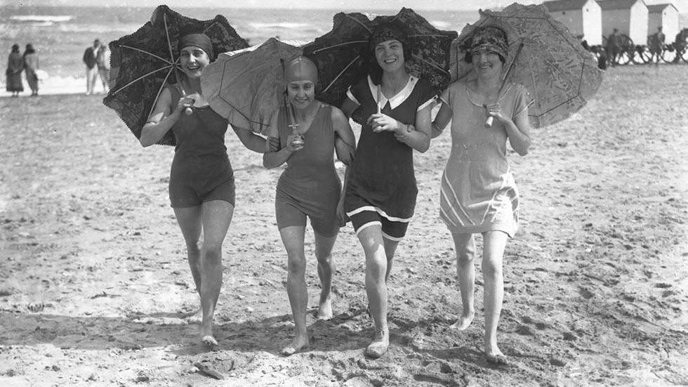 Four bathing belles shading themselves with parasols on the beach at Skegness, Lincolnshire, 1926