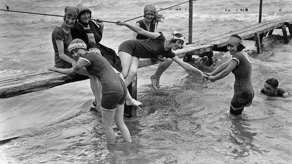 Bather trying to induce her friends into the water at Canvey Island, Essex, 1922