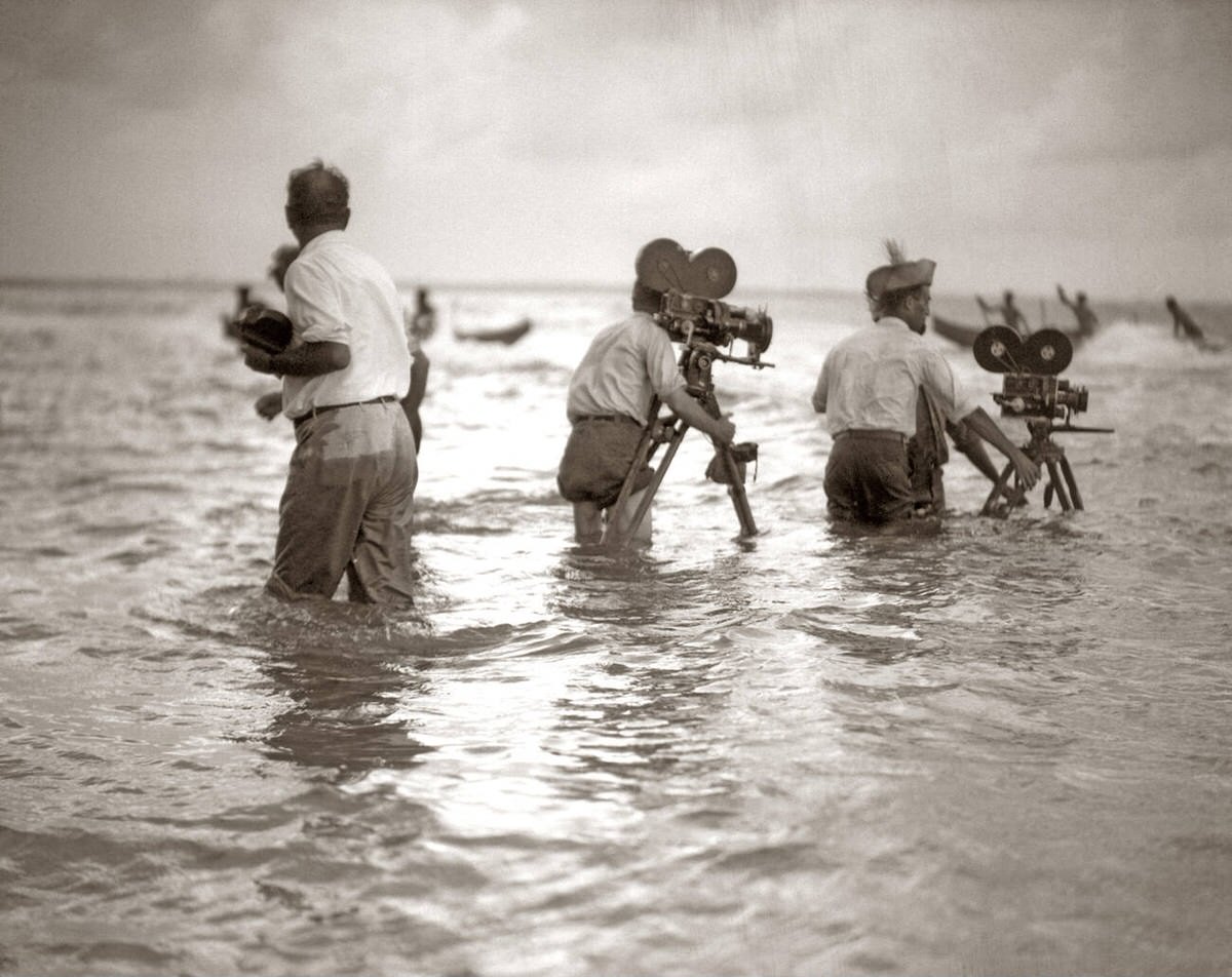 Filmmakers shooting a silent movie in the ocean with outrigger canoes, 1920