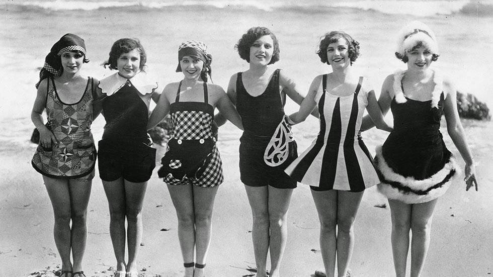 Women showing off unusual and original swimwear on the beach, 1929