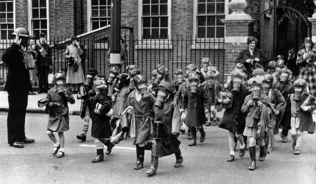 These children in Kingston, Greater London can be seen filing out of their school during a practice gas test. A canister of tear gas was set off so that the students could test their reactions, put on their gas masks and leave the premises. The photograph was taken in June 1941.