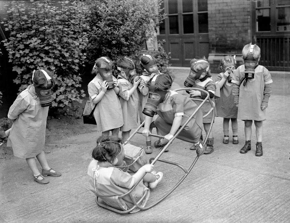 The nursery children pictured above are wearing their masks during recess, adding playful fun to the seriousness of the situation and the discomfort of wearing the devices, circa 1940.