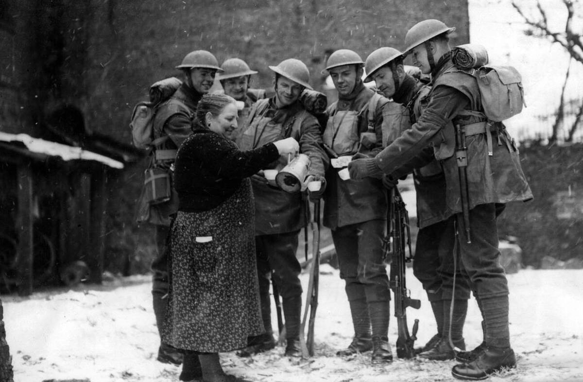 Soldiers of the Welsh Guards offered a drink by a local woman in France, 1940