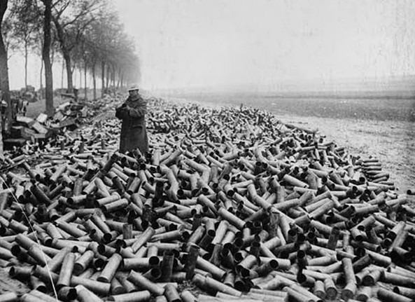 Lone soldier surrounded by a mountain of empty shell cases, France. This lone British soldier up to his knees in spent shell cases, offers a striking impression of the destruction that took place on the Western Front. However, this picture only tells half the story, with the other part of the story being the damage that the shells from these cases inflicted upon the enemy. This photograph was taken by Tom Aitken, and may well have been used for propaganda purposes.