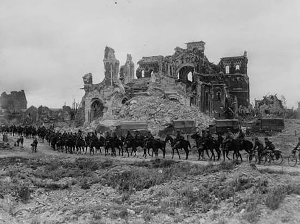 British cavalry passing the ruins of Albert cathedral, France, during World War I. World War I provided endless striking subjects for a photographer as skilled as Tom Aitken. There is something very funereal about the composition of this picture, with the procession of horses in the foreground trooping past the shell of a once-beautiful cathedral. The small town of Albert was badly damaged in fierce fighting during the Allied offensive of August 1918.