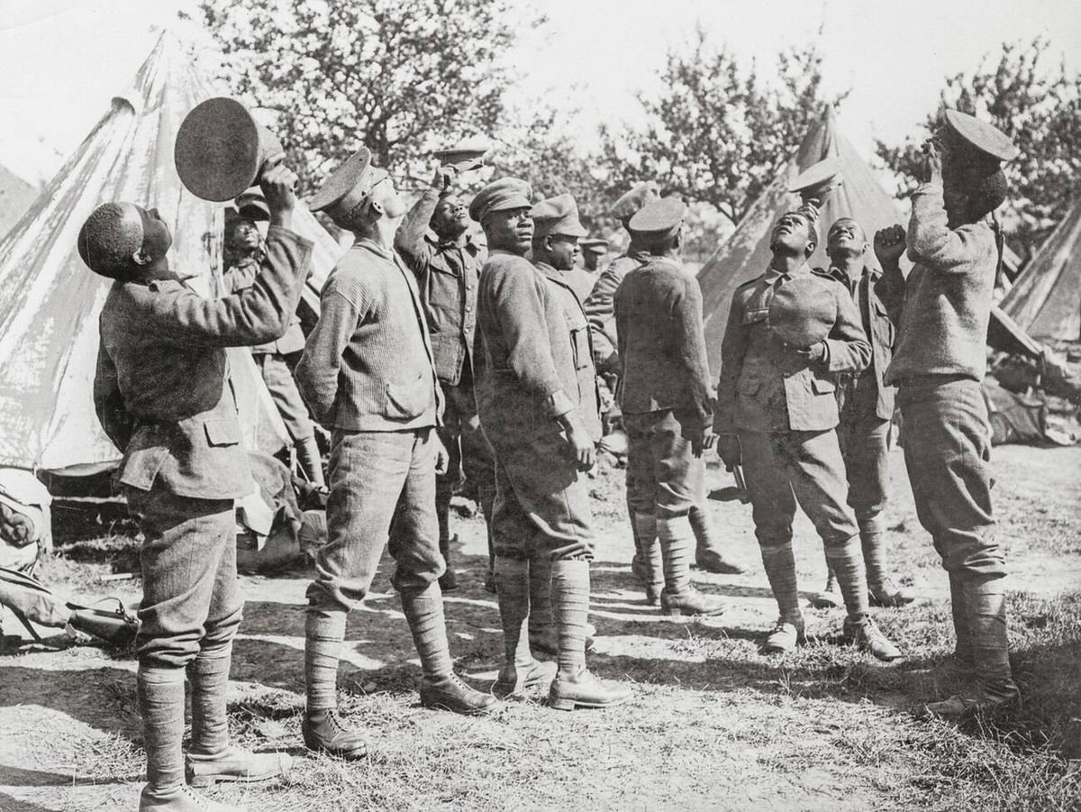 Men from a West Indian Regiment watching a German aeroplane being chased by British planes in France, 1914