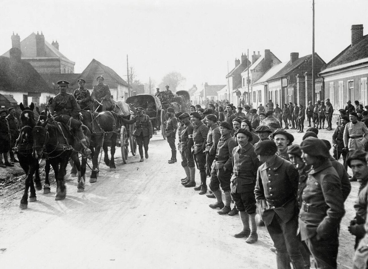 French troops watching British artillery passing through a village in France, 1914