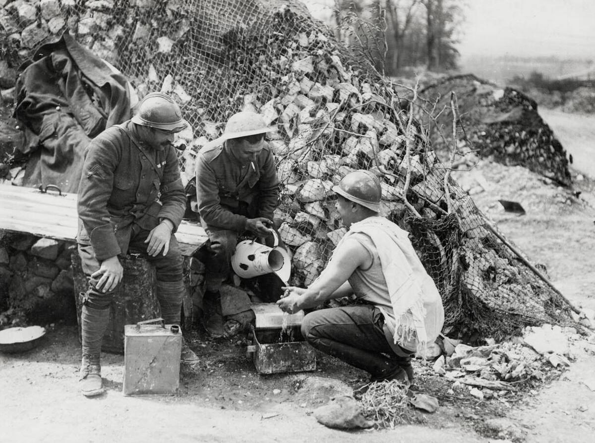 British soldier pouring water for a French soldier's morning wash in France, 1914