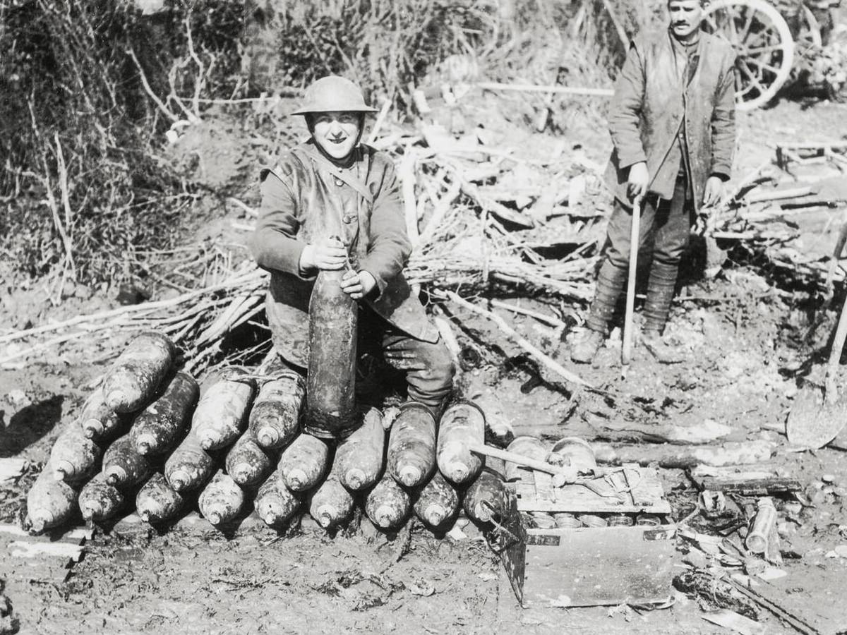 Soldier fusing shells behind British guns in France, 1914