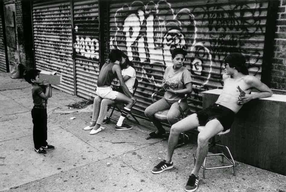 “Pilo Wall.” Teenage boy with toy gun. His son is at left. Two teens kiss, 1985.