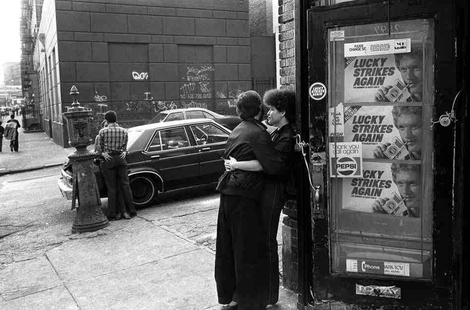Teenage couples kiss on the street corner, 1980s.