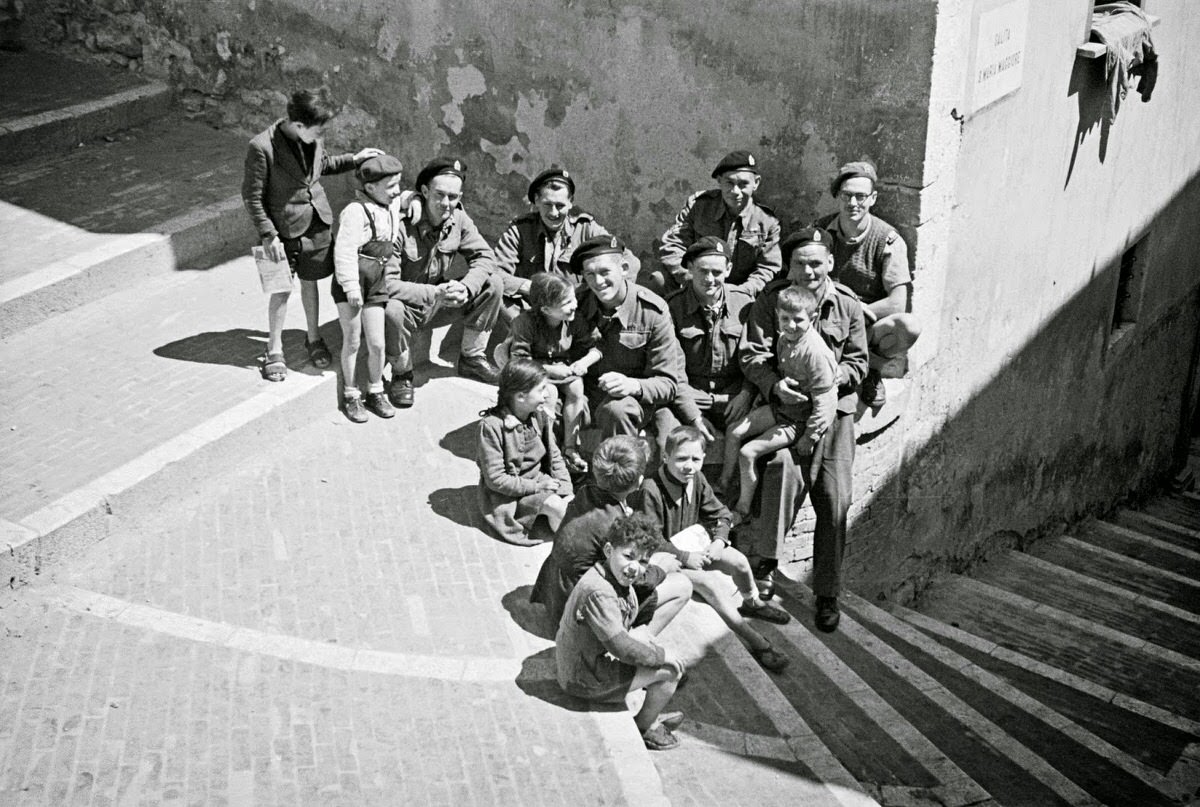Front line troops on leave at Campobasso talk with local children.