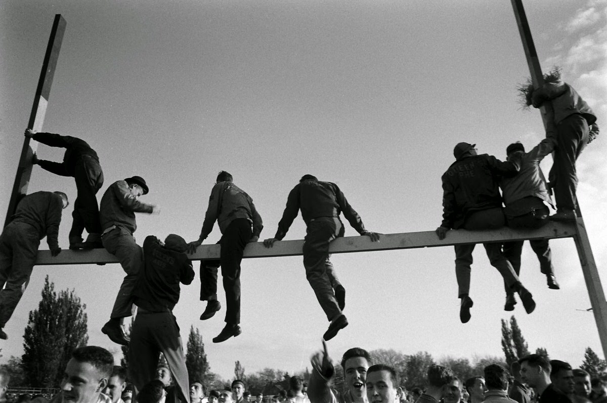 Climbing atop the goal posts after a Canadian college football game, 1954.