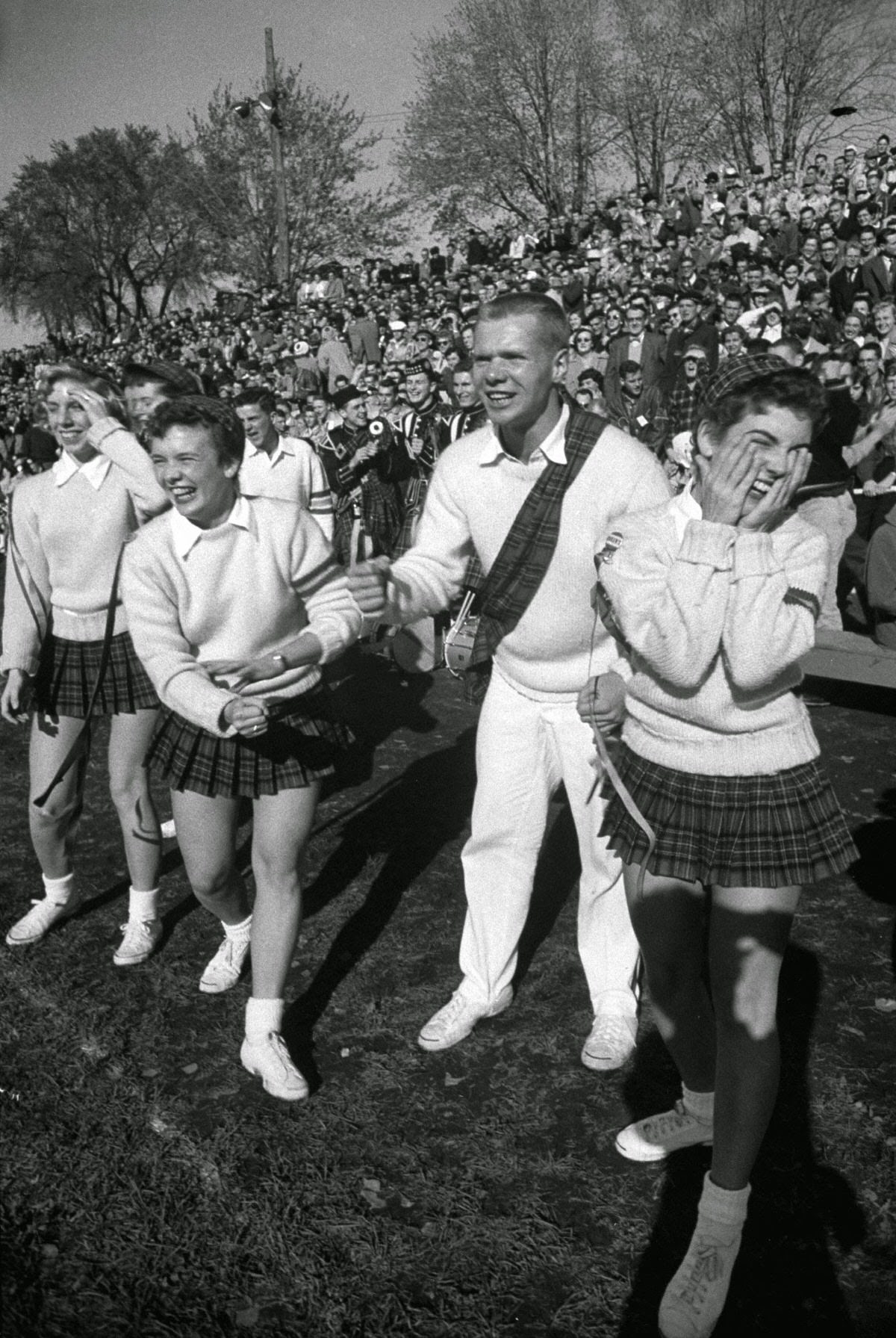 Head cheerleader Al Hart and his kilted helpers look on in amazement after Queen's gain.