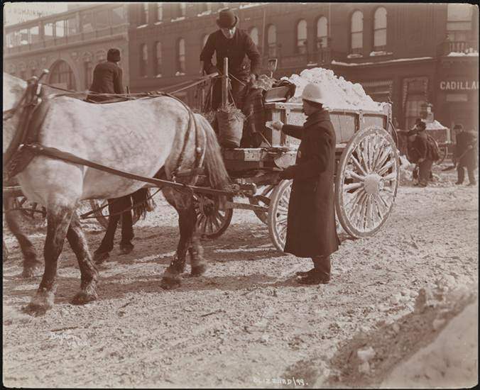 Police officer handing an item to a horse-cart driver hauling snow, 1899
