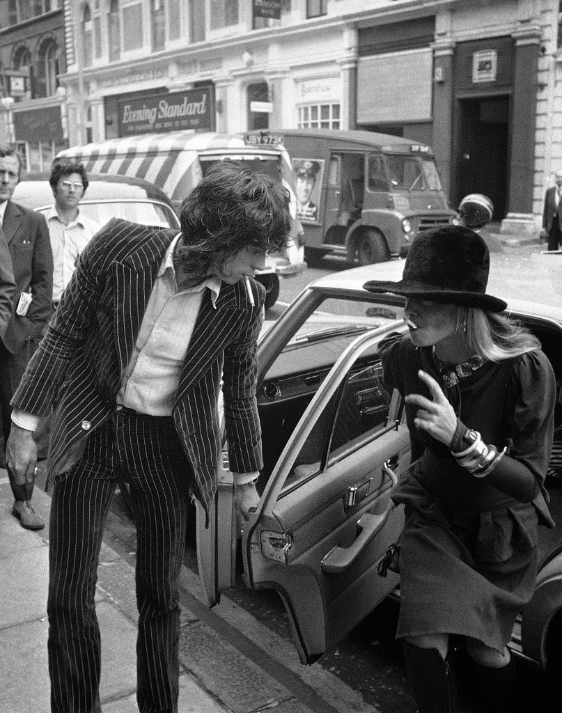 Keith Richards, from The Rolling Stones, 29, accused of drugs and firearm charges, opens the door of car for girlfriend, actress Anita Pallenberg, 31, also charged with possessing drugs, on arrival at Marlborough Street Court in London, England on June 27, 1973.