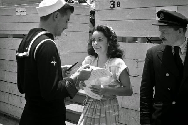 In 1945, at age 13 and already a veteran of five films, Elizabeth Taylor signs autographs during a charity cricket match at Los Angeles' Gilmore Stadium.
