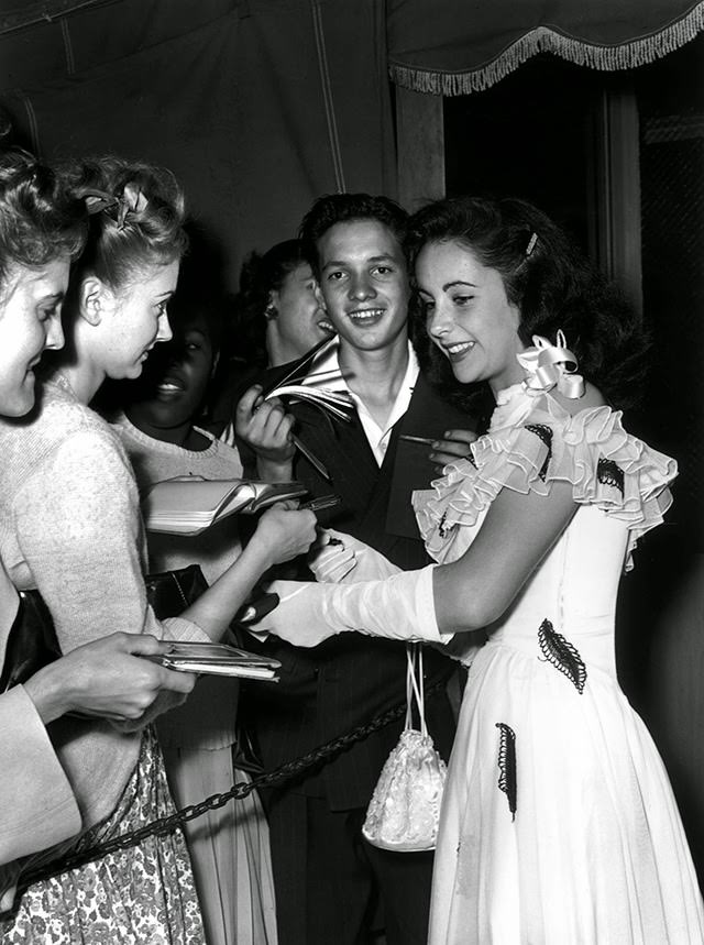 Taylor signing autographs for her fans at a nightclub in 1946.