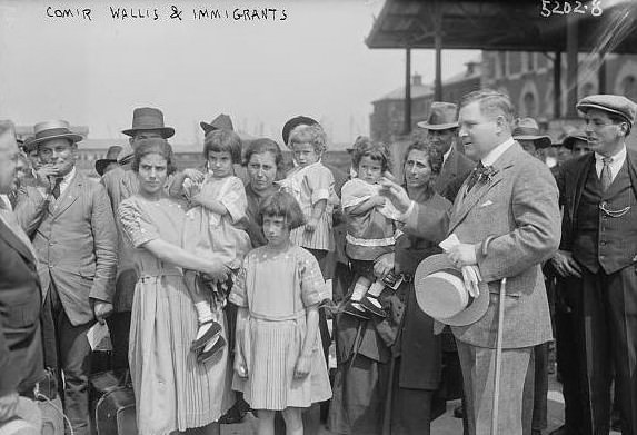 Commissioner Wallis with immigrants.