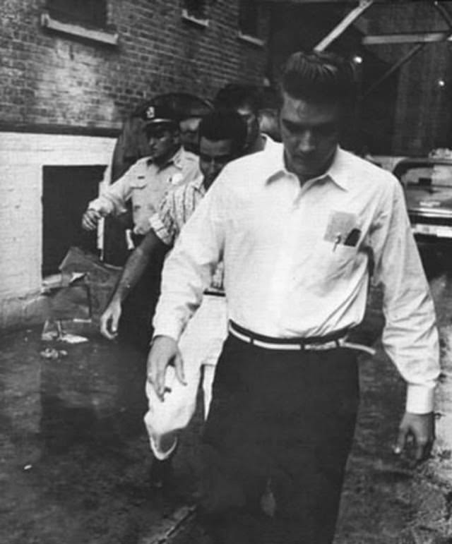 Elvis Presley arriving through the alley at the rear of the theater, 1956