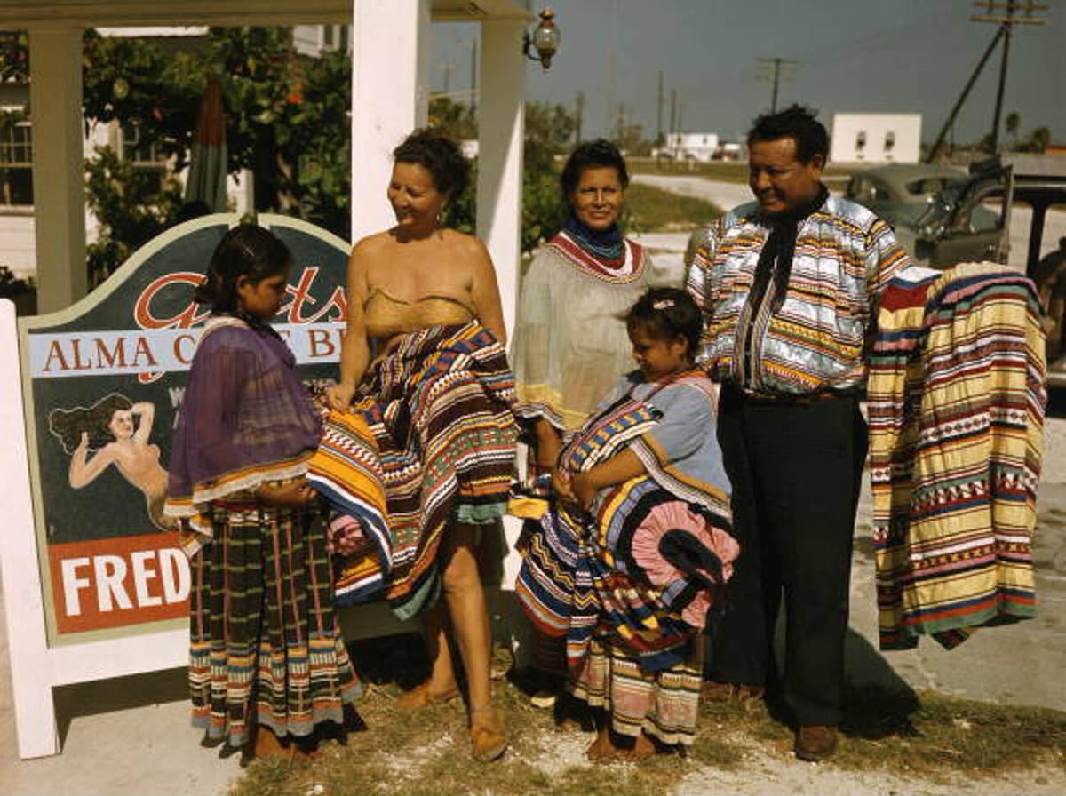 Seminole family selling patchwork clothing near the Brighton Reservation, 1940s