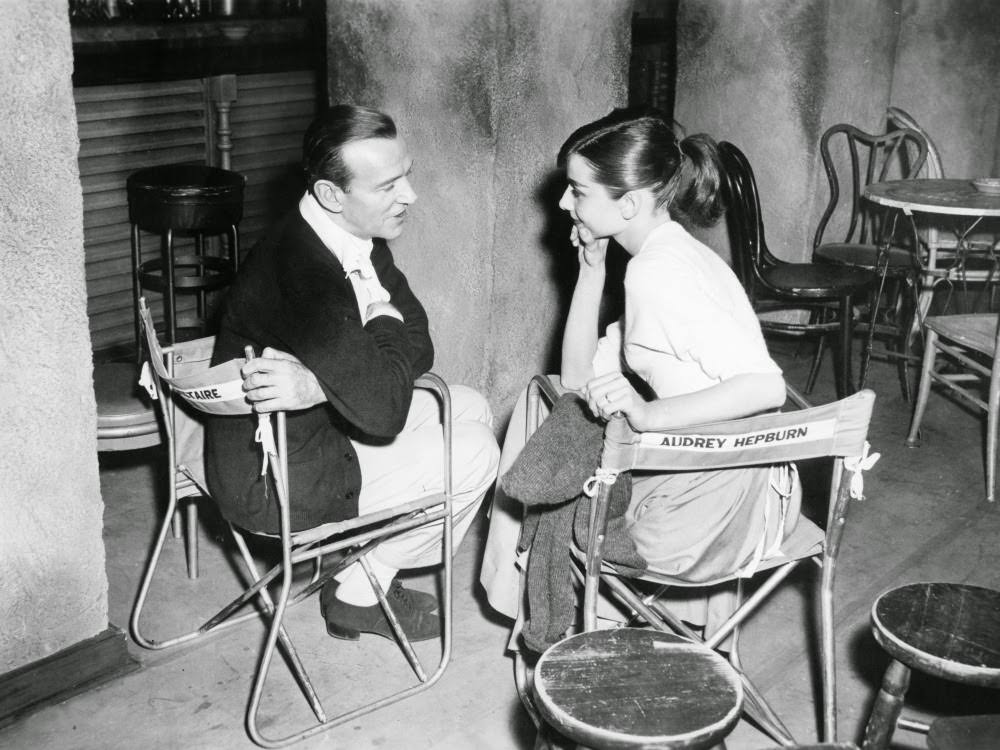 Astaire and Hepburn chat on the set for a boho Parisian café