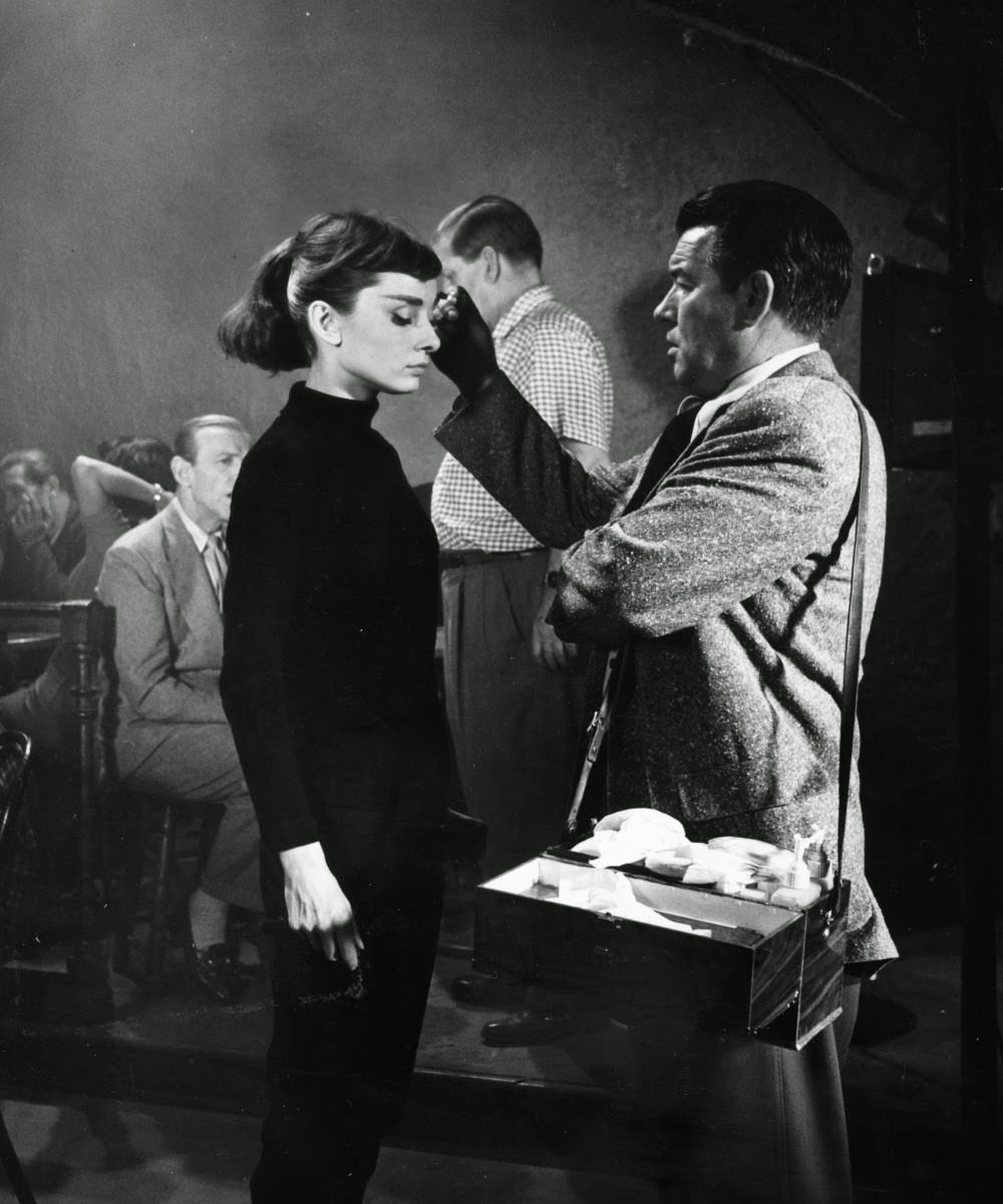 Hepburn’s personal makeup artist Wally Westmore applies her mascara. He was known to separate each of her eyelashes with a sewing pin so that the results would look more defined on camera.