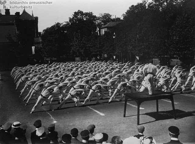 This photograph by the Haeckel brothers shows athletes performing calisthenics at a gymnastics festival (June 6-9, 1911) in Gotha (Thuringia) in which teams from various universities took part. In Germany, clubs and societies came together around various interests, including gymnastics. Public sports and gymnastics festivals, such as the one shown here, created a sense of community and solidarity among participants. They brought Germans from various regions together, strengthening the country’s vibrant associational culture. Photo: Gebrüder Haeckel.