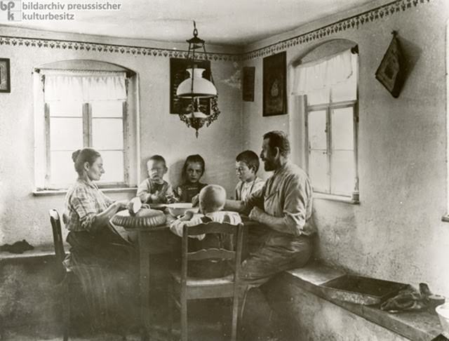 Wilhelmine-era German households were largely patriarchal. Women played multiple roles, often contributing to the family income through work in the fields, even as they cared for the children. They were also responsible for meals, which consisted primarily of bread and potatoes, supplemented by fats, oils, and an occasional cut of meat. Here, we see a rural family enjoying a modest midday meal together, as was customary, ca. 1912.