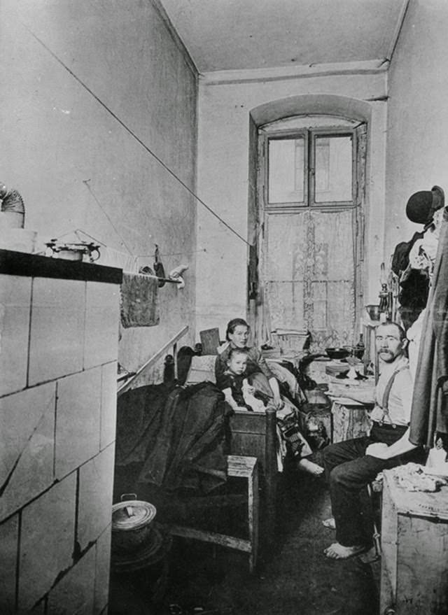 Working class quarters, c. 1910. In Germany, industrialization and urbanization went hand in hand, as individuals and entire families left the countryside and moved to cities in search of work. Living conditions were often miserable: working-class housing was dank, cramped, and overcrowded, with little fresh air or natural light. Entire families lived in narrow rooms without indoor plumbing. One such quarter on Berlin's Liegnitzer Straße is depicted here. The rent for this type of space would have consumed a large portion of a family’s income.