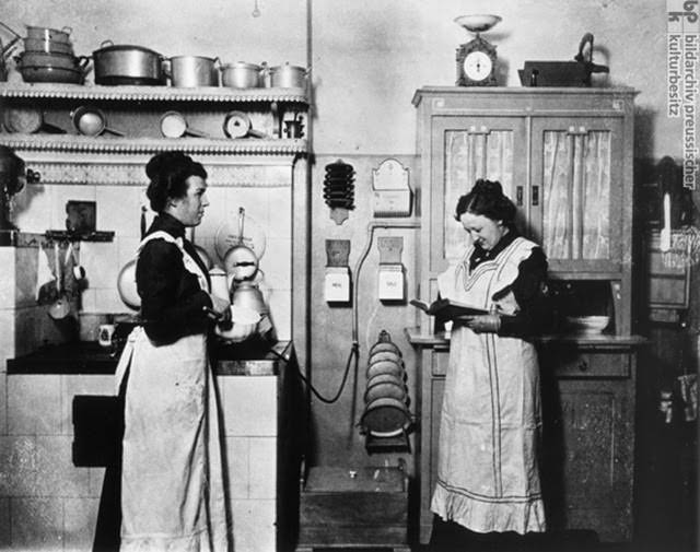 The kitchen staff, c. 1910. Wealthy bourgeois families hired outside help both as a practical matter and as a mark of status. The vast majority of domestic servants were women. While the family matriarch oversaw the household, the kitchen staff took care of the cooking and other laborious chores. Here we see two domestic servants in a bourgeois kitchen. Cooks were not only responsible for the preparation of food, they also bought the ingredients, washed the dishes, and cleaned the dining room after meals. The woman on the right is probably consulting a cookbook in preparation for the family’s next meal.