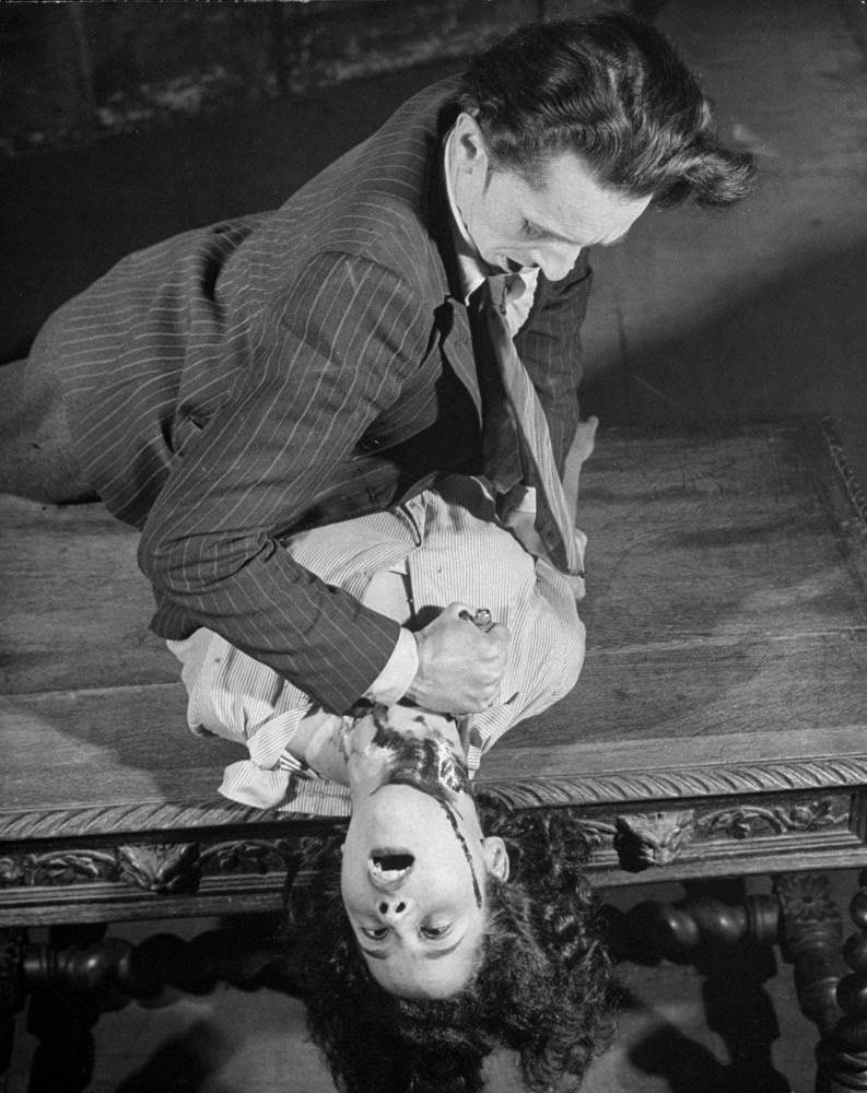 Actor performing a throat-cutting scene using a trick dagger in The Hussy at the Grand Guignol, 1947