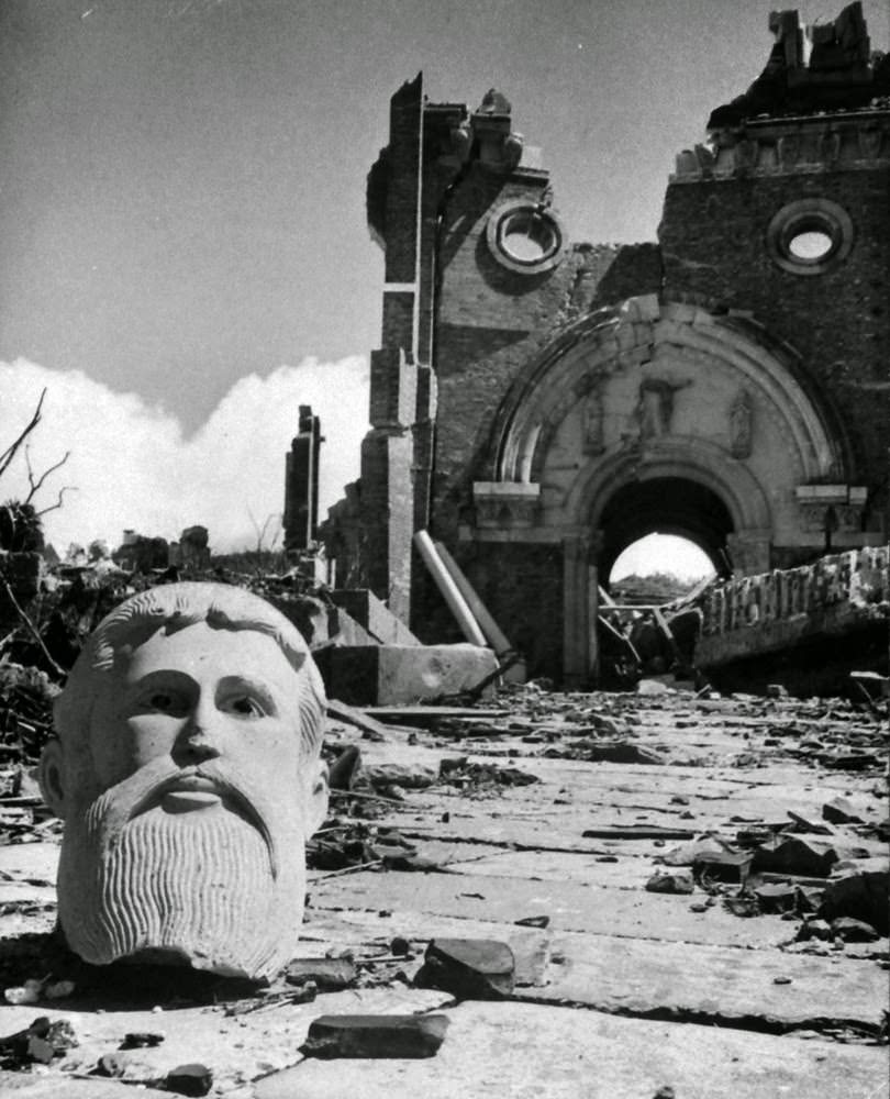 Bust in front of destroyed cathedral two miles from the atomic bomb detonation site, Nagasaki, Japan, 1945.