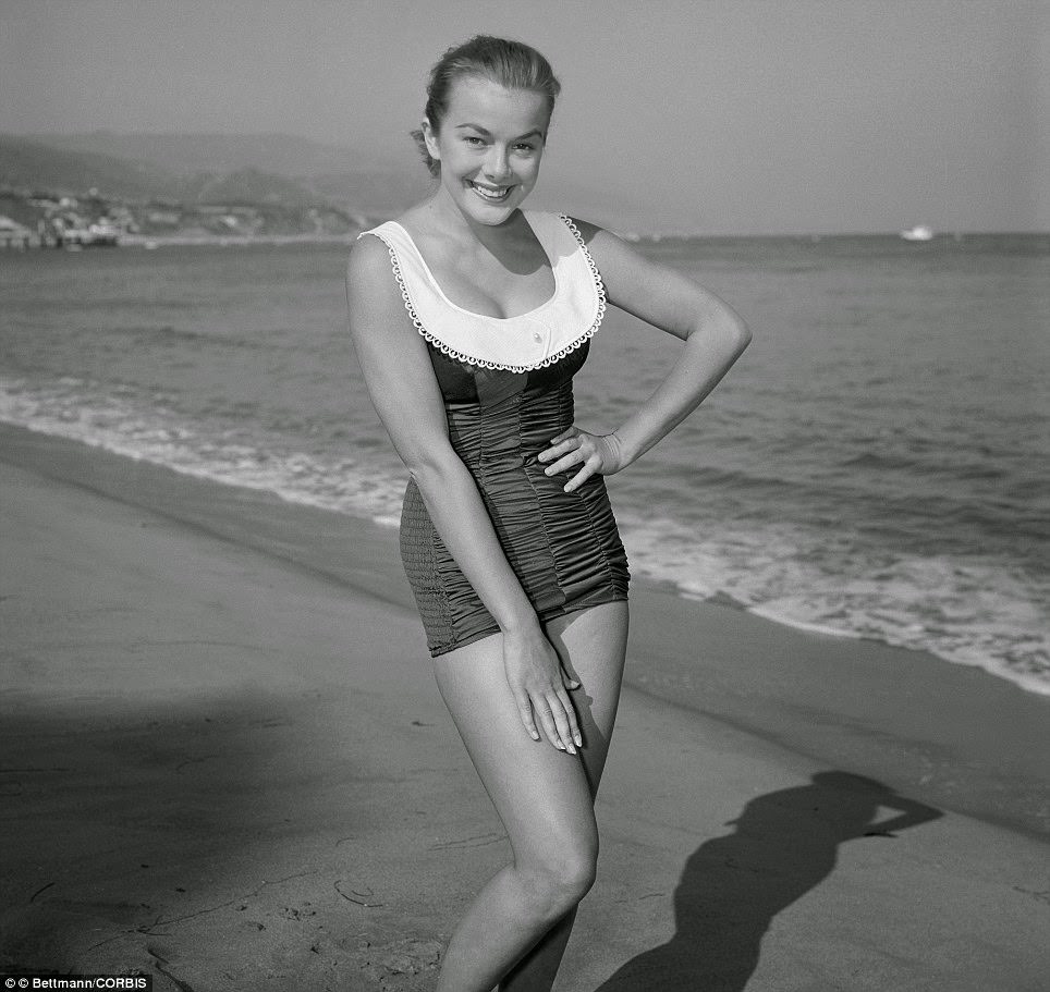Marjorie Helen modeling a white pique collar swimsuit on a Los Angeles beach, 1956