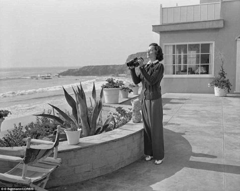 Merle Oberon using binoculars at her home on Trancas Beach, 1948