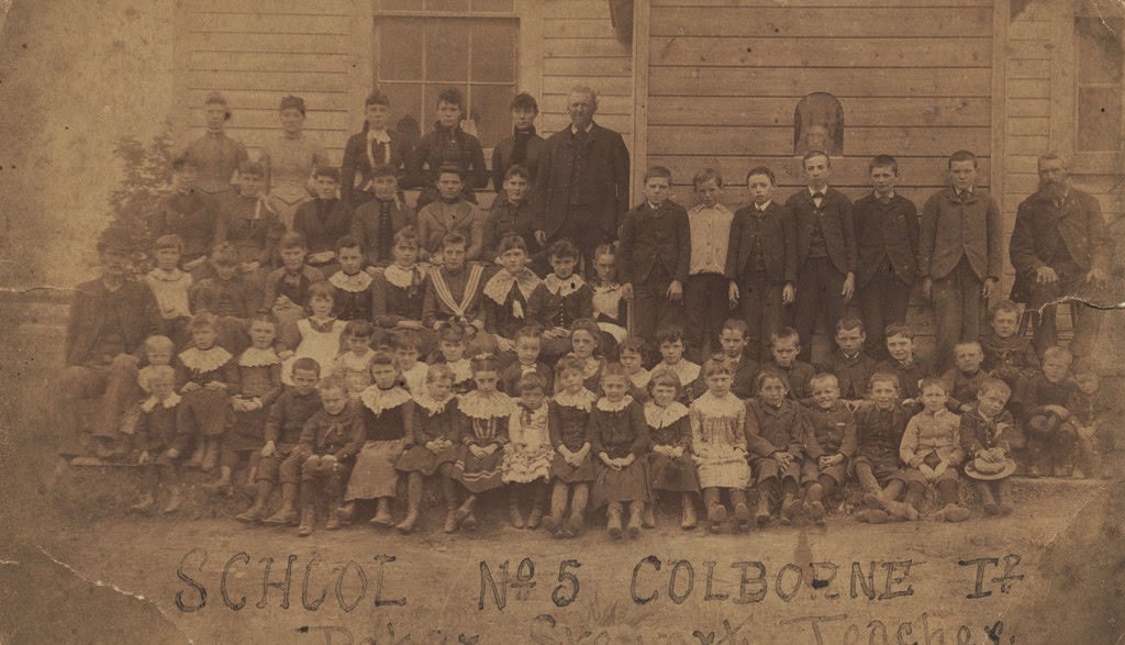 Group portrait of 67 students and teachers in front of School No. 5 in Colborne, 1890s