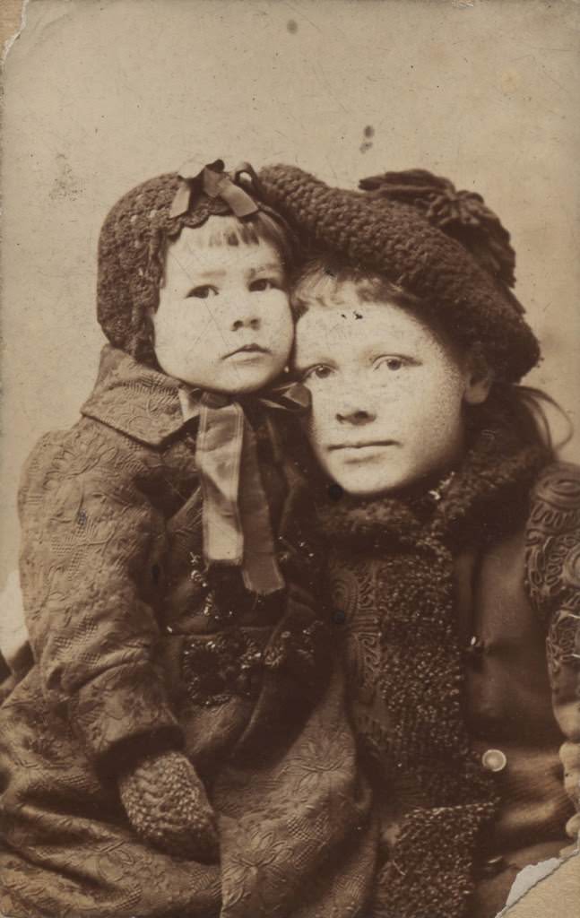 Studio portrait of two children dressed for winter, 1892
