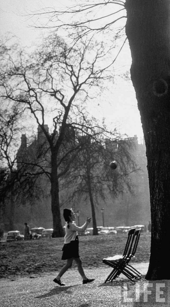 A young girl playing ball in Hyde park on a spring day.