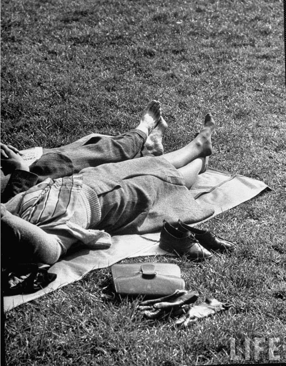 Couples kicking off their shoes while laying in the park on a sunnny spring day.