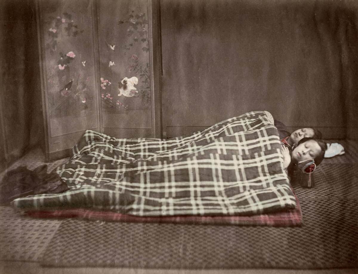 Young women sleeping under eiderdown, 1880s