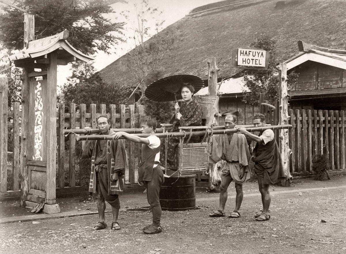 Woman in a sedan chair with bearers at the Hafuya Hotel, 1880s