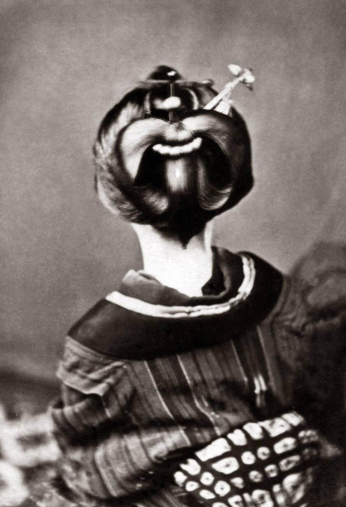 Geisha showing an ornate hairstyle and obi sash, 1880s
