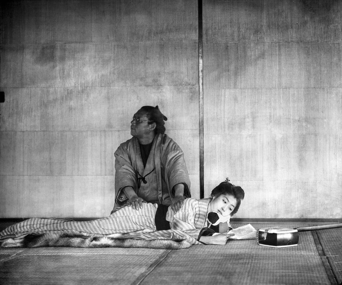 Blind masseur giving a massage to a woman, 1890s