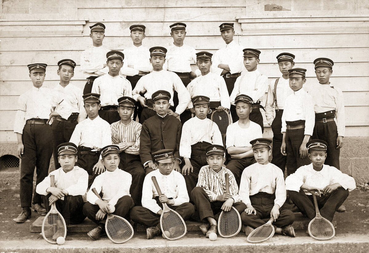 Male high school students in uniform with tennis rackets, 1890s