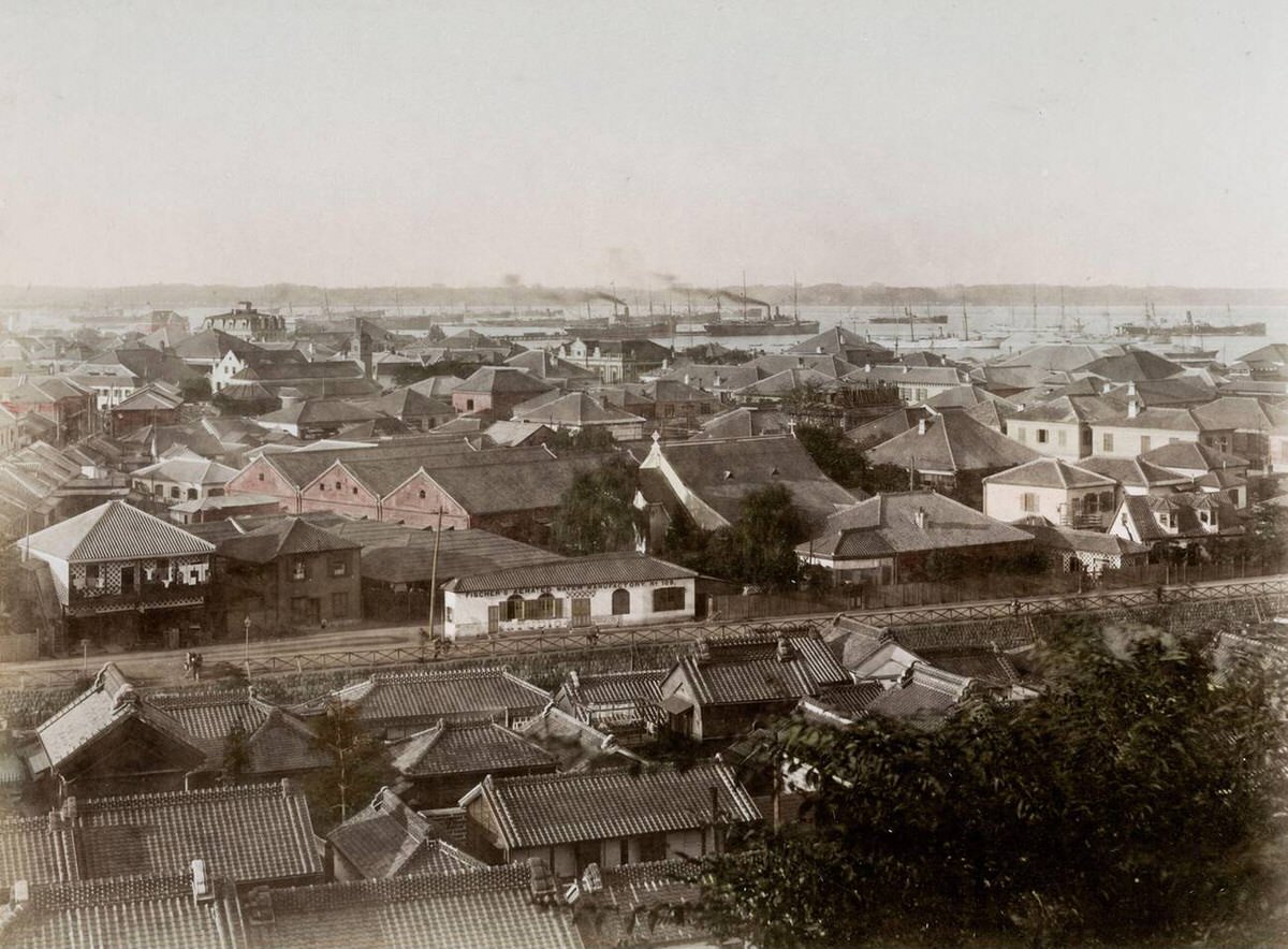 View of Yokohama looking over the creek toward ships in the harbor, 1880s