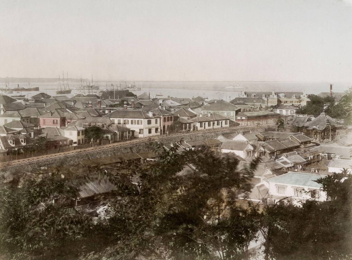 View of Yokohama looking over the creek toward ships in the harbor, 1880s