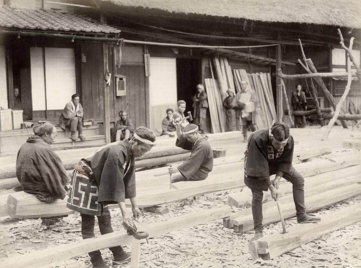Carpenters at work with chisels and axes on large timbers, 1890